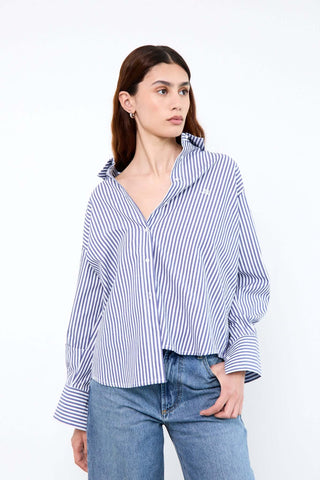 Woman wearing a blue and white striped shirt with rolled-up sleeves