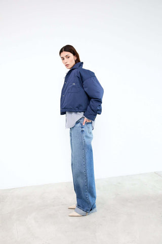 Person wearing a blue jacket and jeans 