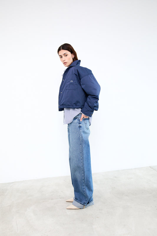 Person wearing a blue jacket and jeans 