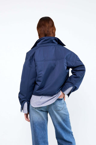 Person wearing a blue jacket and jeans 