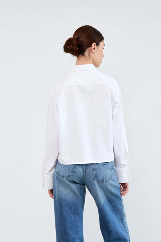 Person wearing a white shirt and blue jeans