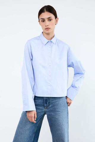 Person wearing a light blue shirt and jeans