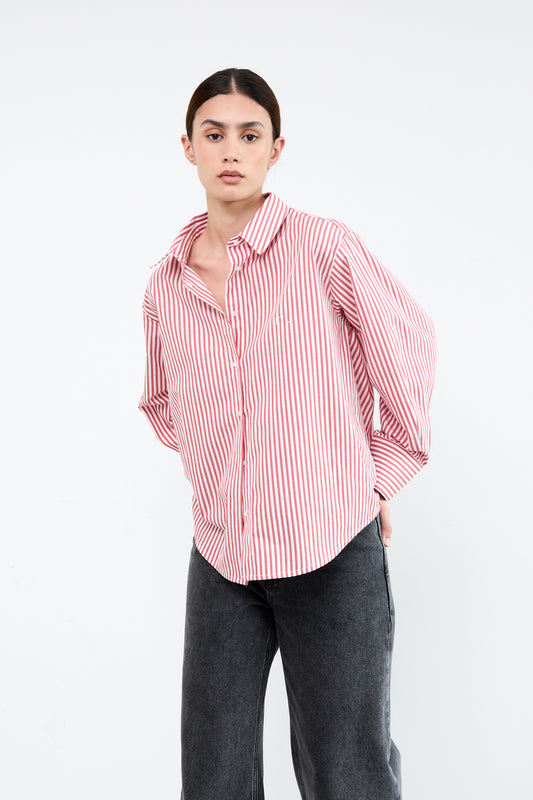 Woman wearing a red and white striped shirt with rolled-up sleeves 