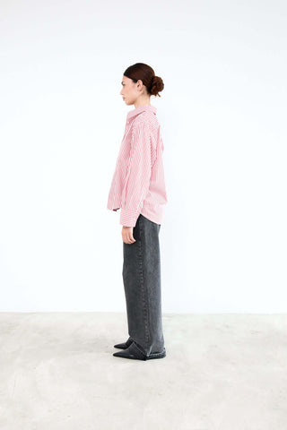 Person wearing a pink checkered shirt and dark pants