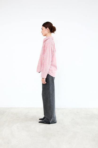 Person wearing a pink checkered shirt and dark pants