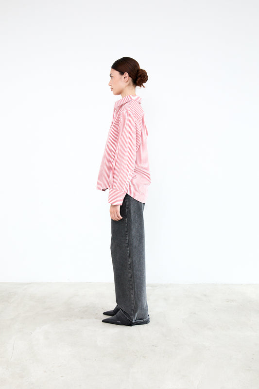 Person wearing a pink checkered shirt and dark pants