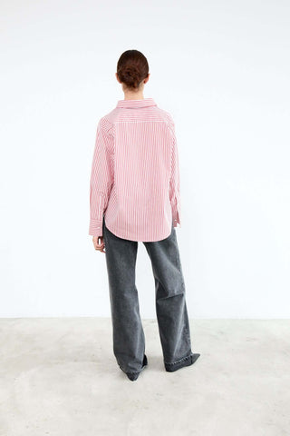 Person wearing a pink and white striped shirt and gray pants 