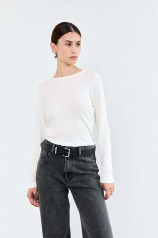 Woman wearing a white long-sleeve top and black jeans