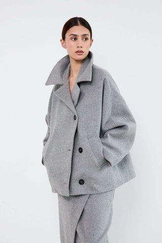 Woman wearing a gray coat and pants 