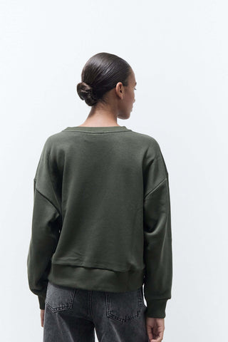 Person wearing a green sweatshirt on a white background