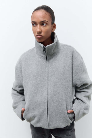 Person wearing a gray zip-up jacket 