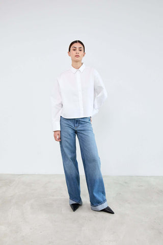 Person wearing a white shirt and blue jeans