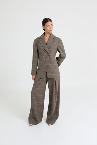 Woman wearing a brown checkered suit on a white background