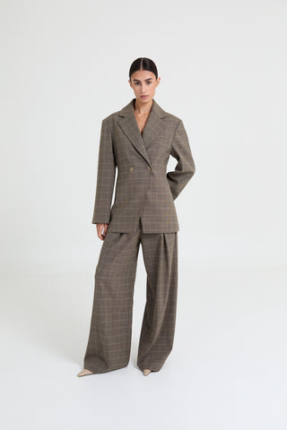 Woman wearing a brown plaid suit on a white background