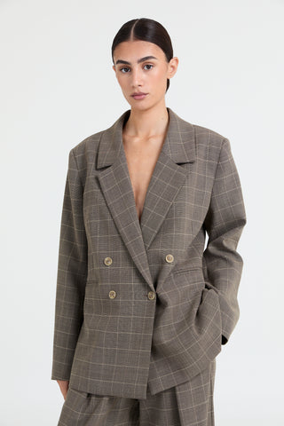 Woman wearing a gray checkered suit on a white background