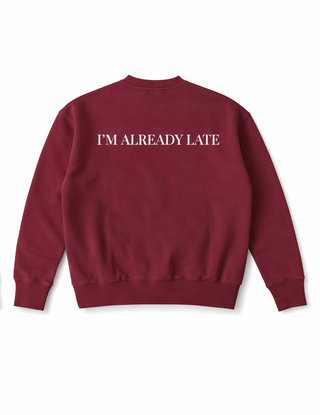Maroon sweatshirt with 'I'M ALREADY LATE' text on the back against a white background