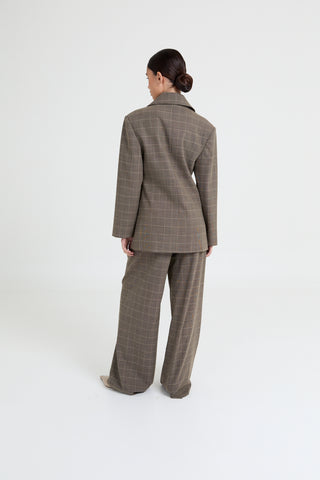 Person wearing a brown checkered suit on a white background