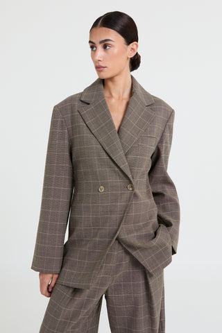 Woman wearing a brown checkered suit on a white background