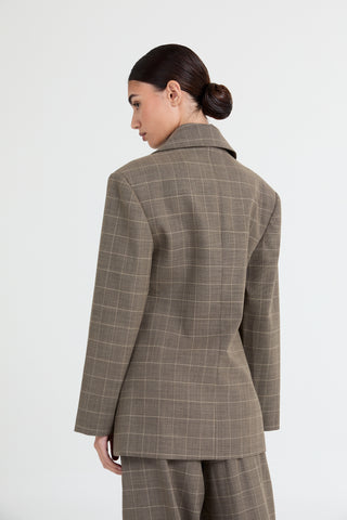 Woman wearing a brown checkered suit on a white background