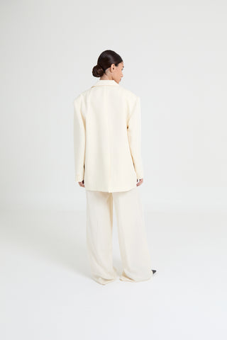 Person wearing a light-colored outfit on a white background