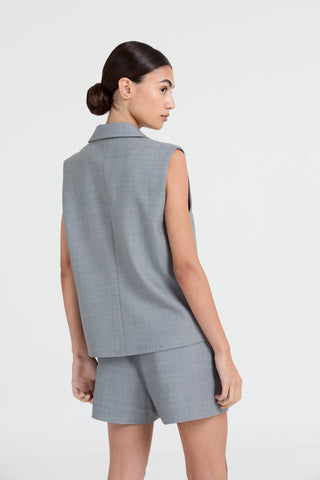 Woman wearing a gray sleeveless top and shorts set on a white background