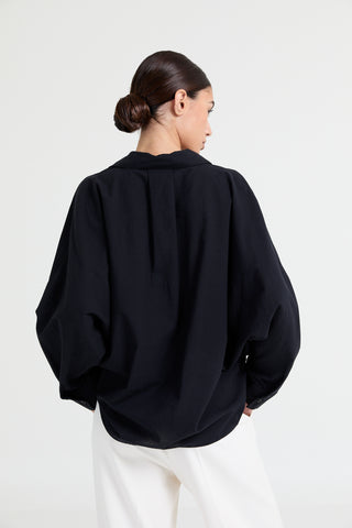 Person wearing a black oversized sweater on a white background