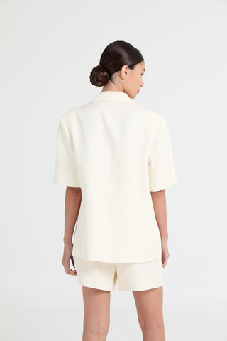 Woman wearing a white outfit on a plain background