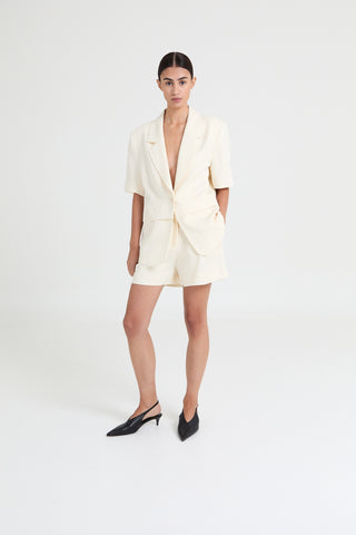 Woman wearing a white blazer dress on a white background