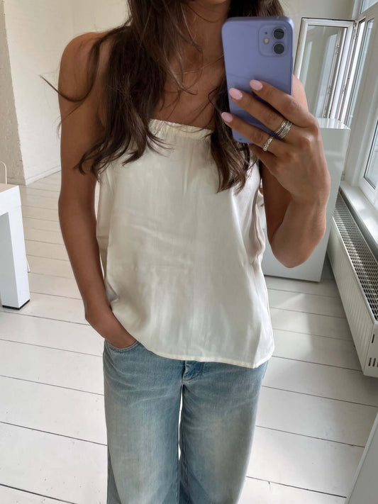 Person wearing a white top and blue jeans