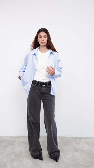 Model wearing light blue shirt with white tee and wide-leg jeans
