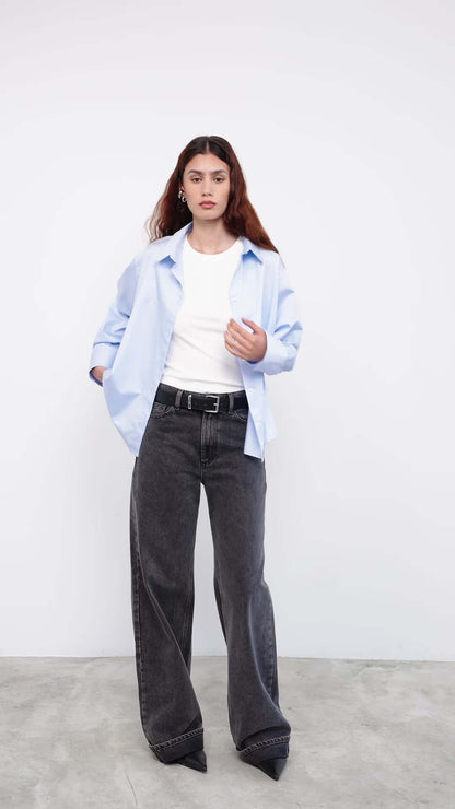 Model wearing light blue shirt with white tee and wide-leg jeans