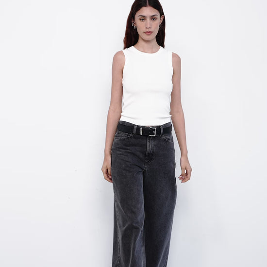 Person wearing gray wide-leg jeans and a white top