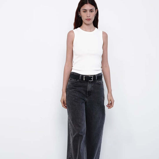 Person wearing gray wide-leg jeans and a white top