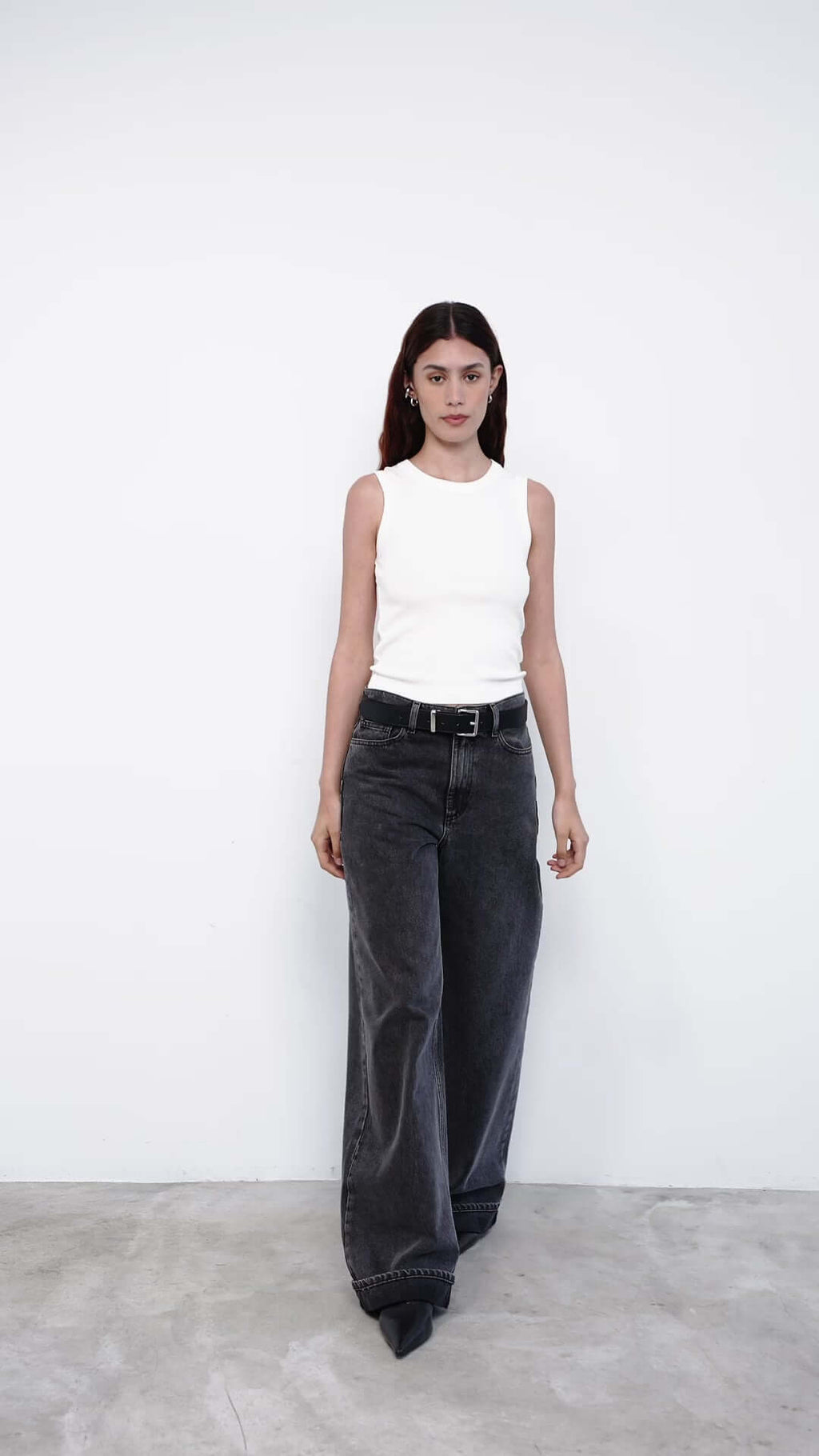 Person wearing gray wide-leg jeans and a white top